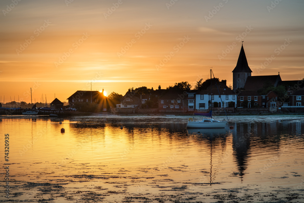 Beautiful Summer sunset landscape over low tide harbor with moor