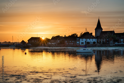Beautiful Summer sunset landscape over low tide harbor with moor