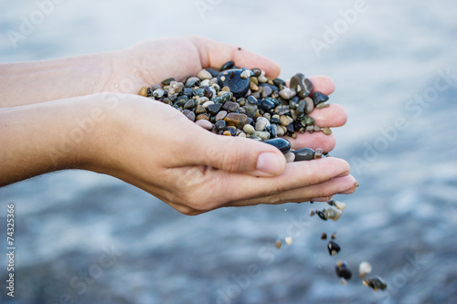A girl plays with sea stones