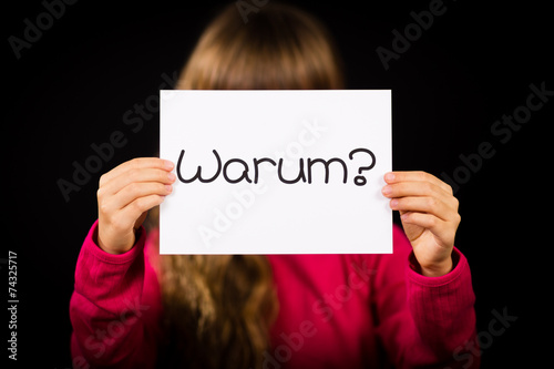 Child holding sign with German word Warum - Why