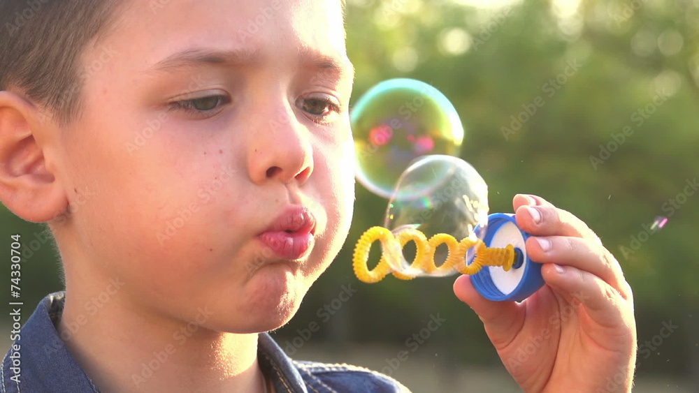 beautiful caucasian boy playing with soap bubbles in the park 4 beautiful caucasian boy playing with soap bubbles in the park 4