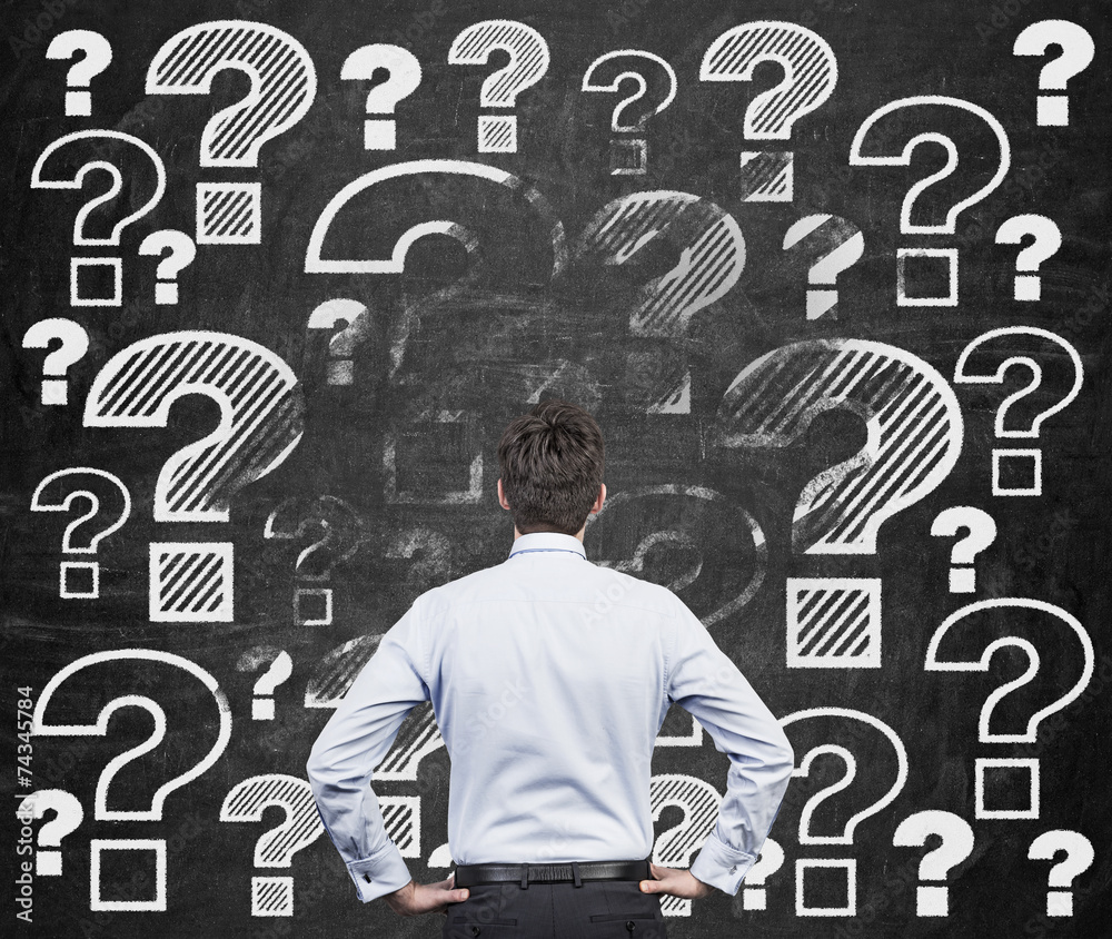 businessman looking at question marks businessman looking at question marks