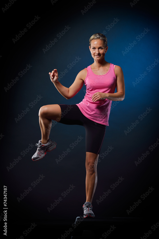 young woman doing step exercises in the gym young woman doing step exercises in the gym