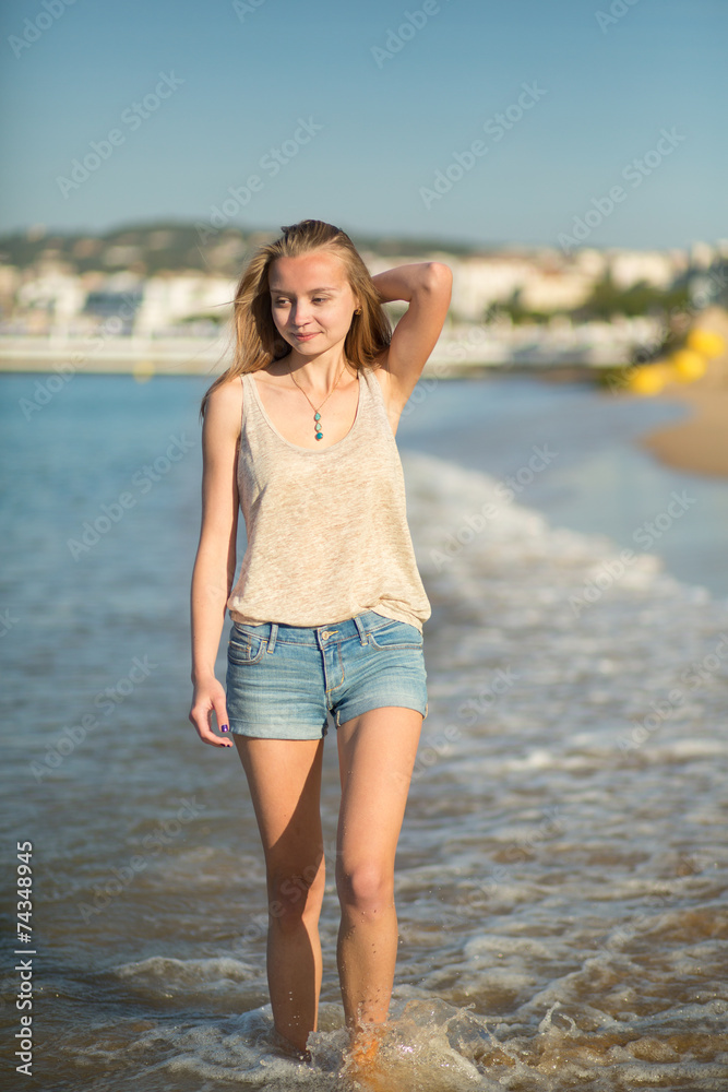 Young girl walking on the beach in Cannes, France