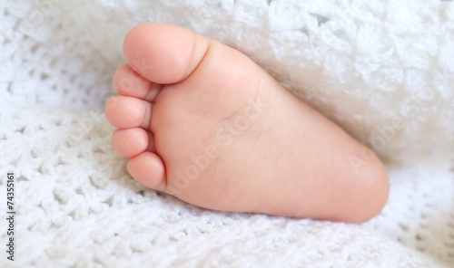 Baby feet wrapped in a white blanket.