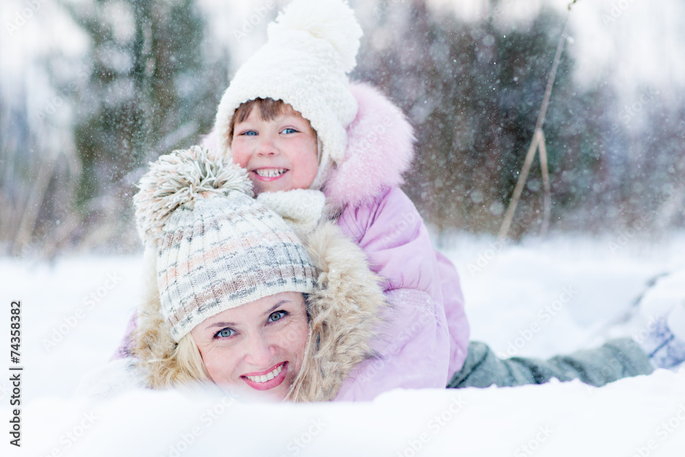 Happy parent and kid playing with snow in winter outdoor