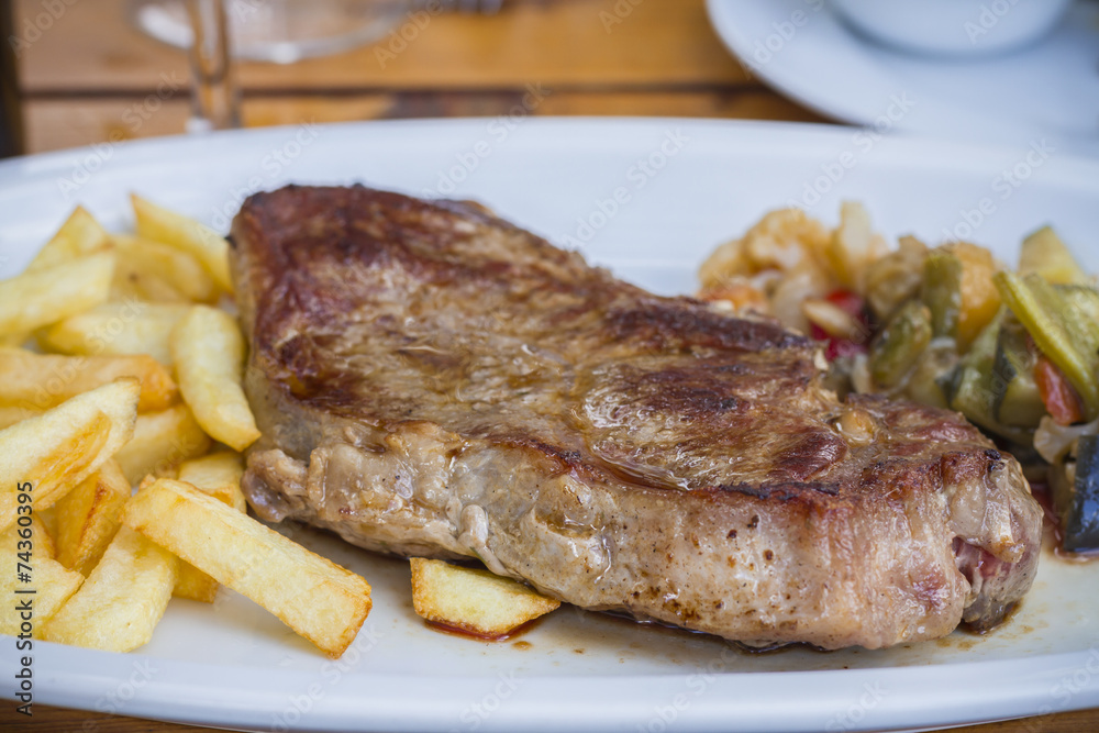 Beef steak with fries and vegetables Beef steak with fries and vegetables