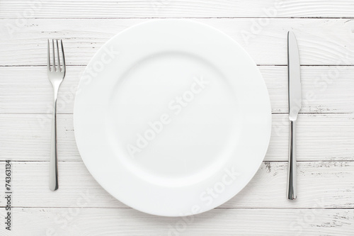plate, knife and fork on white vintage wooden table