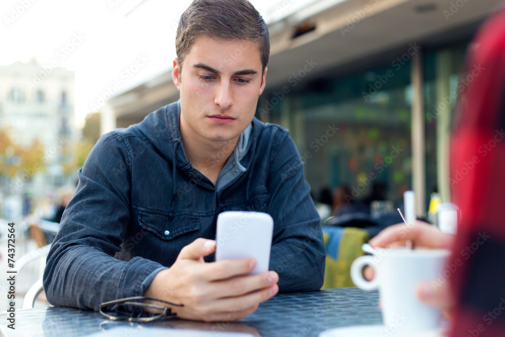 Young entrepreneur using his mobile phone at coffee shop. Young entrepreneur using his mobile phone at coffee shop.