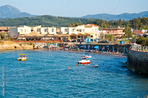 Sidary resort, people sunbath on the sandy beach. Corfu, Greece. photo
