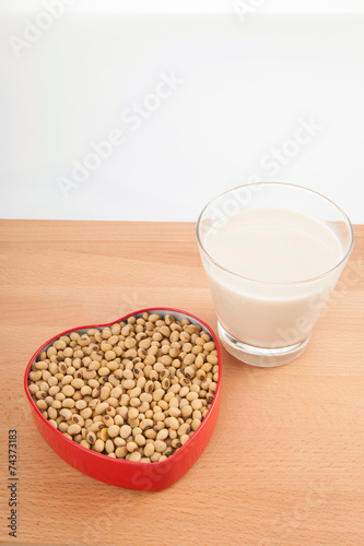 Soy milk in glass with soybeans in heart shape box