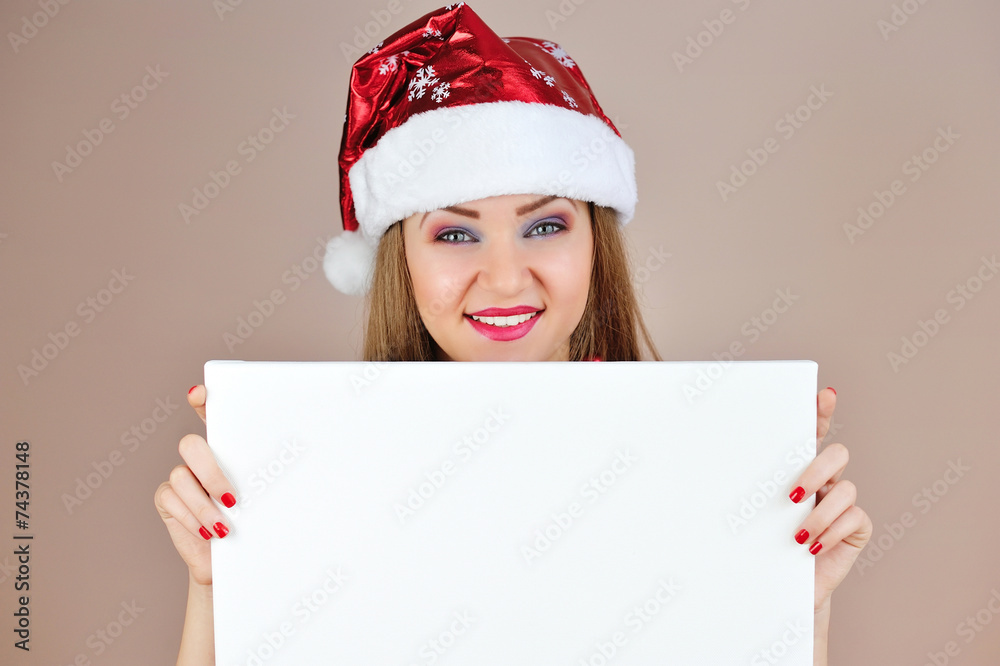 Beautiful christmas woman in santa hat with blank white board Beautiful christmas woman in santa hat with blank white board