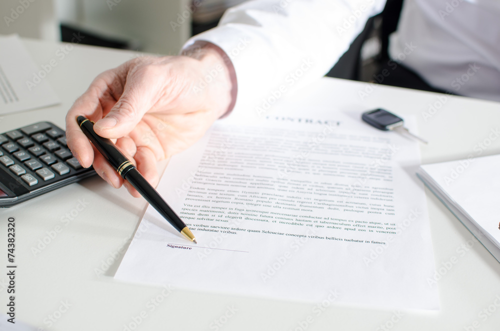 Car salesman showing a sales contract Car salesman showing a sales contract