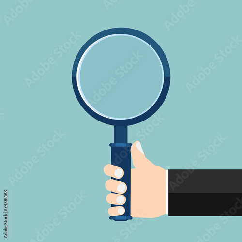 Magnifying glass in a hand