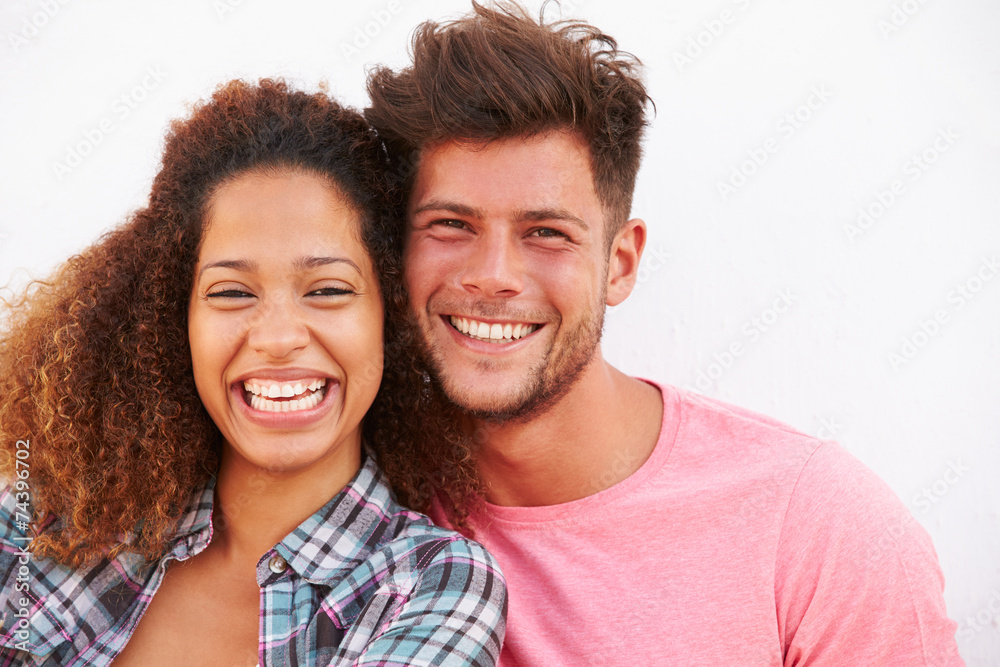 Portrait Of Couple Standing Outdoors Against White Wall Portrait Of Couple Standing Outdoors Against White Wall