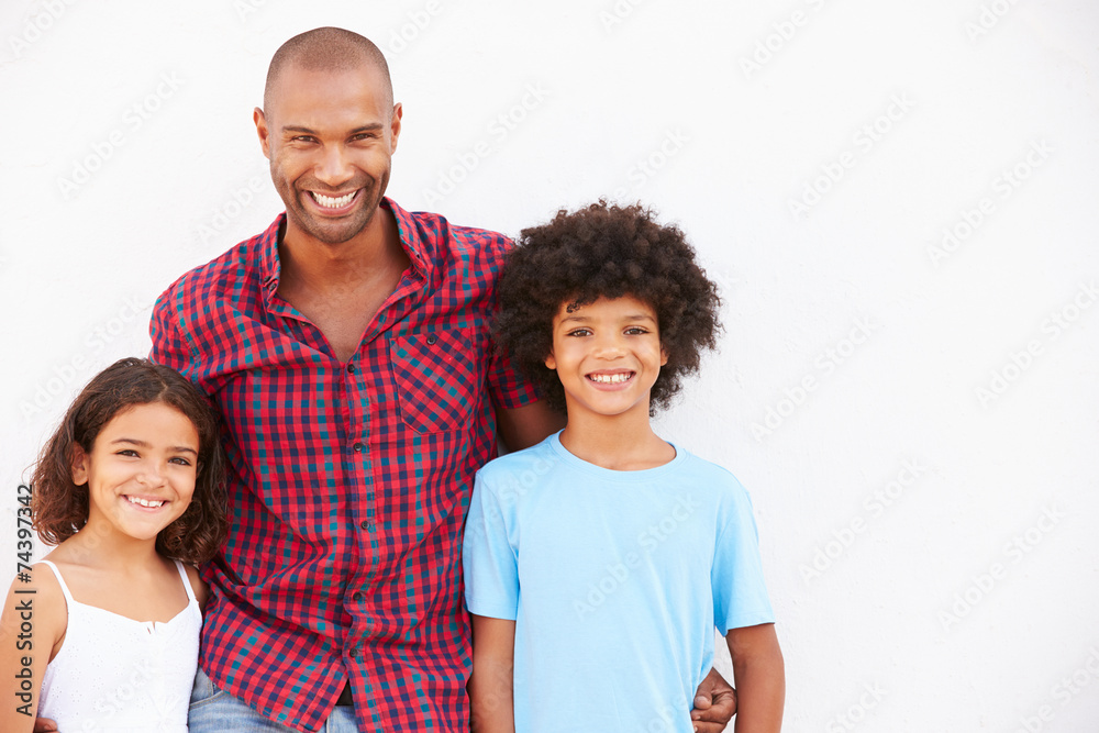 Father And Children Standing Outdoors Against White Wall Father And Children Standing Outdoors Against White Wall