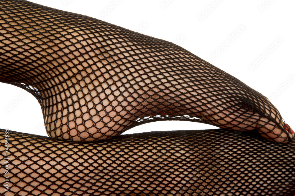 Naklejka premium Woman legs black fishnet close foot on leg