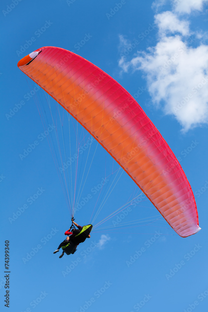 Red paraglider in the blue sky with clouds Red paraglider in the blue sky with clouds