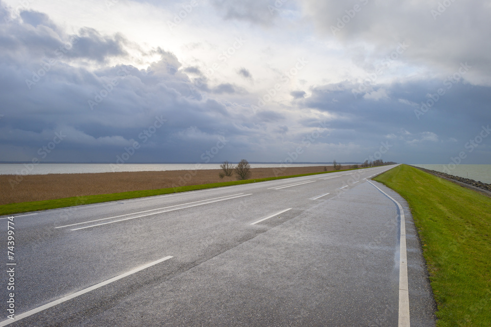 Road on a dike along a lake in autumn