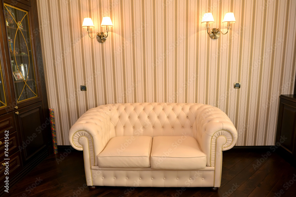 Obraz premium Fragment of an interior of a house office with a white sofa
