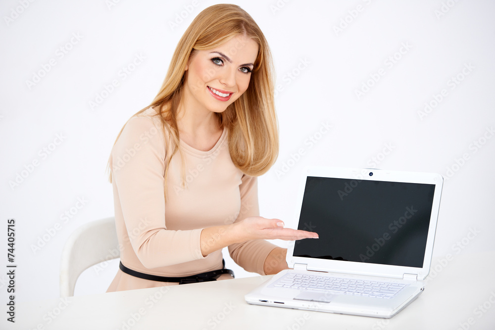 Sitting Smiling Woman Showing Laptop on Table Sitting Smiling Woman Showing Laptop on Table