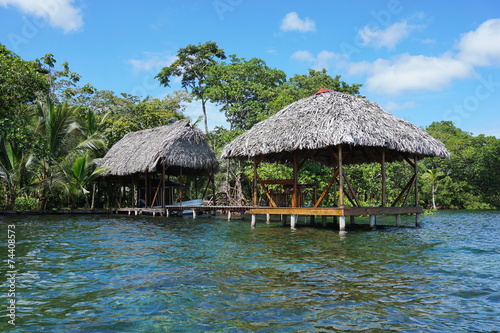 Thatched tropical hut and boathouse over the sea