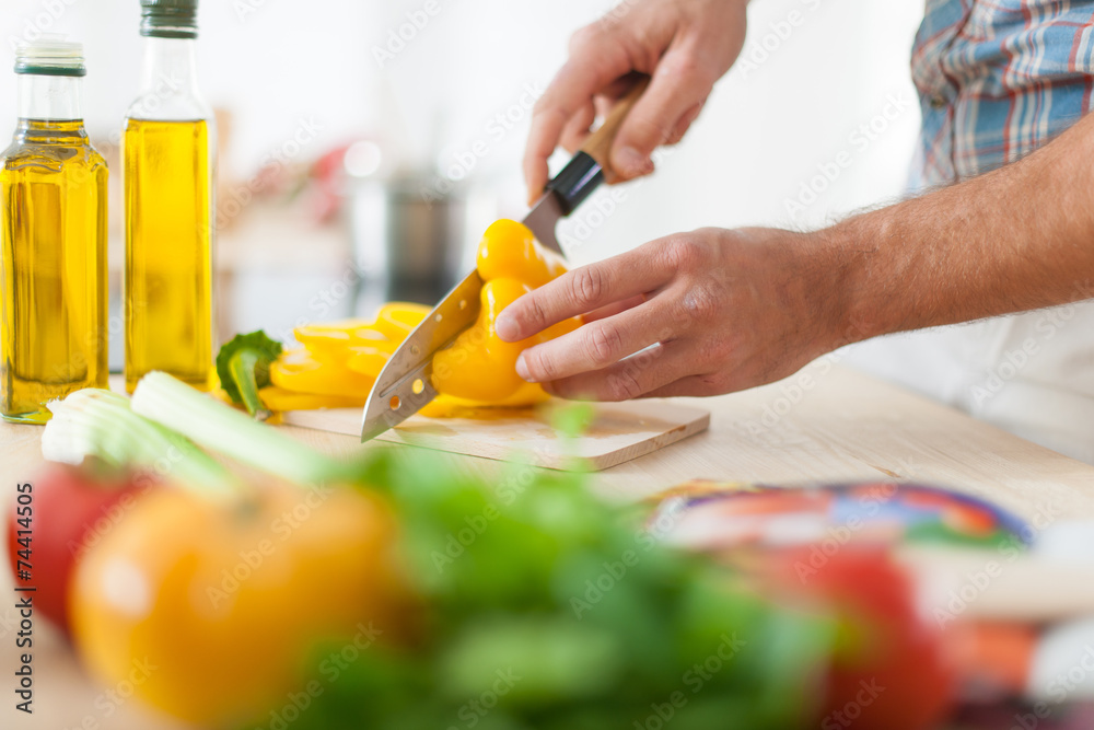 closeup on man's hands cutting vegetables closeup on man's hands cutting vegetables