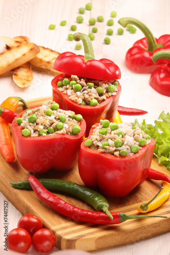 Peppers stuffed with meat rice and vegetables on cutting board