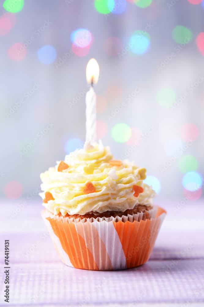 Delicious birthday cupcake on table on light background