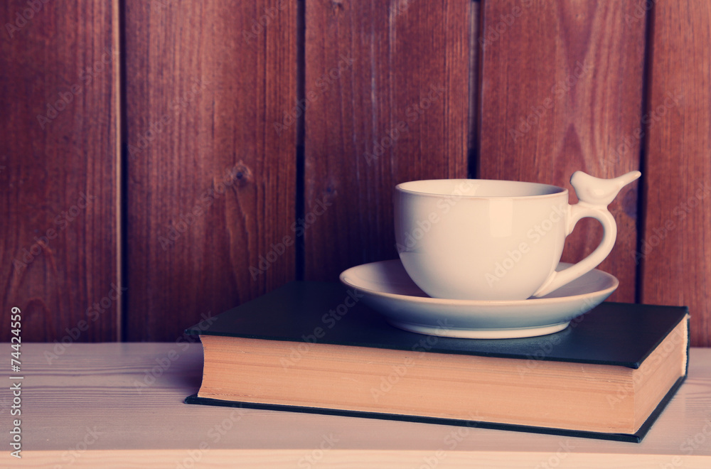 Old books and cup of coffee on table