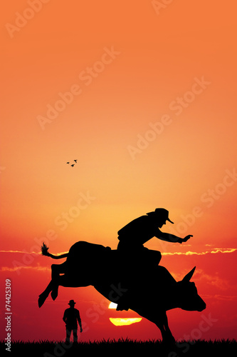 Bull rider at sunset