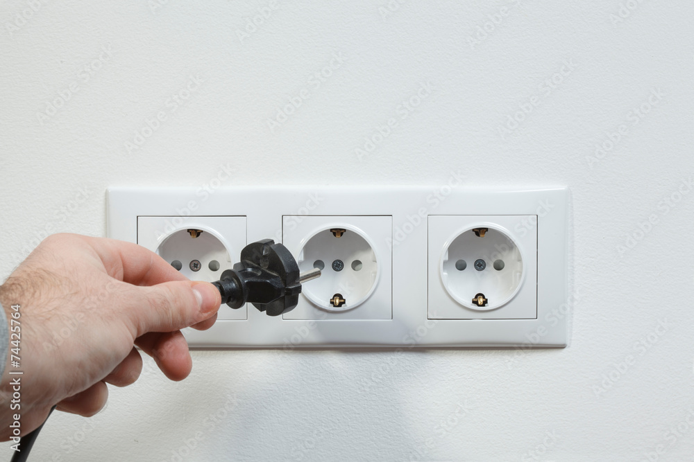 Plugging electrical cable to socket Stock Photo | Adobe Stock