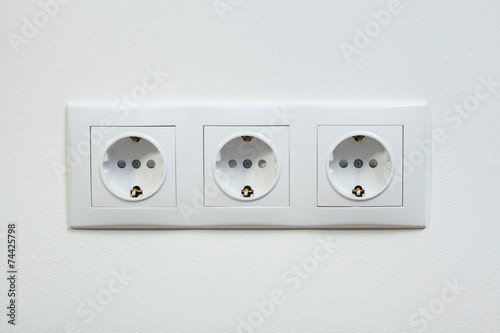 White triple electric socket on the wall