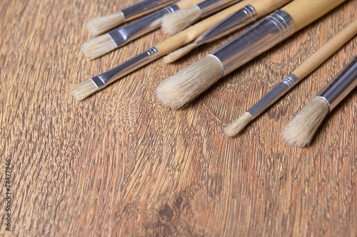 close up of paint brushes on wooden table