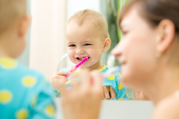 Sierkussen Tandarts mother and kid look at mirror during teeth brushing  © Oksana Kuzmina