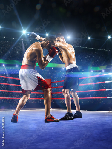 Two professionl boxers are fighting on arena