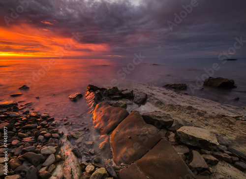 Fototapeta Naklejka Na Ścianę i Meble -  	zachód słońca nad morską, skalistą plażą