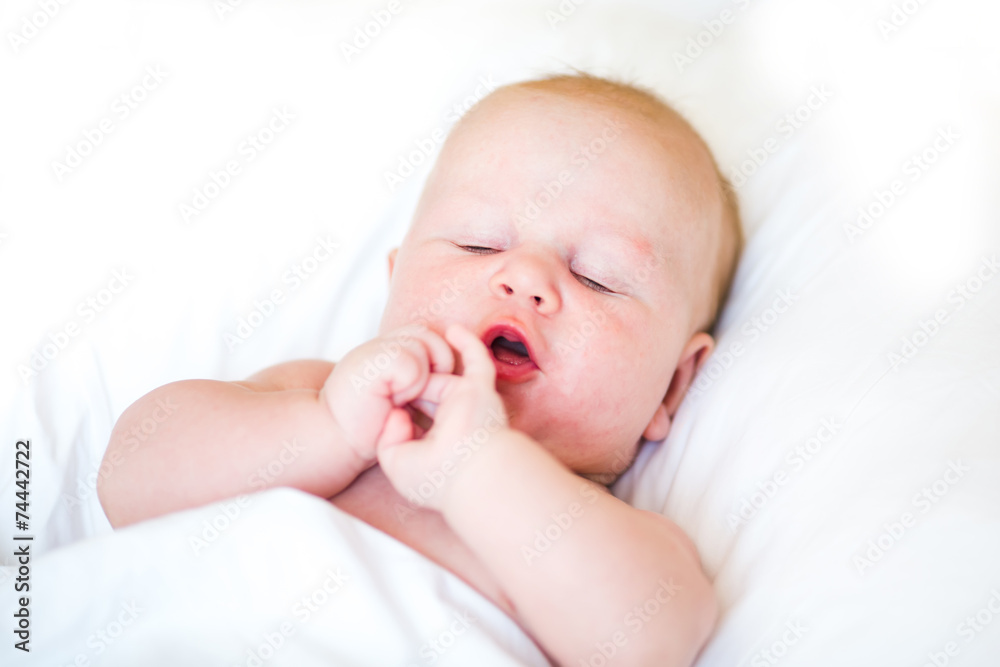 Peaceful newborn baby lying on a bed