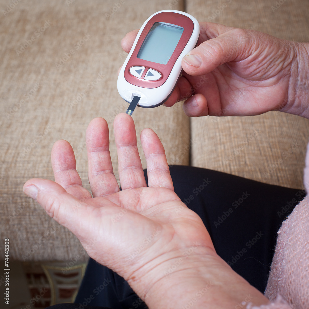 Fototapeta premium Nurse takes test for sugar in blood of elderly woman at home.