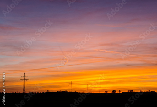 power line silhouettes in front of a colorful sunset sky