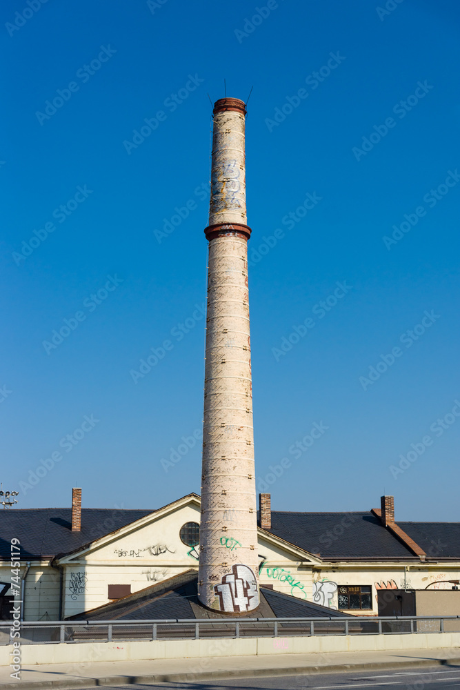 Old brick chimney against the blue sky.