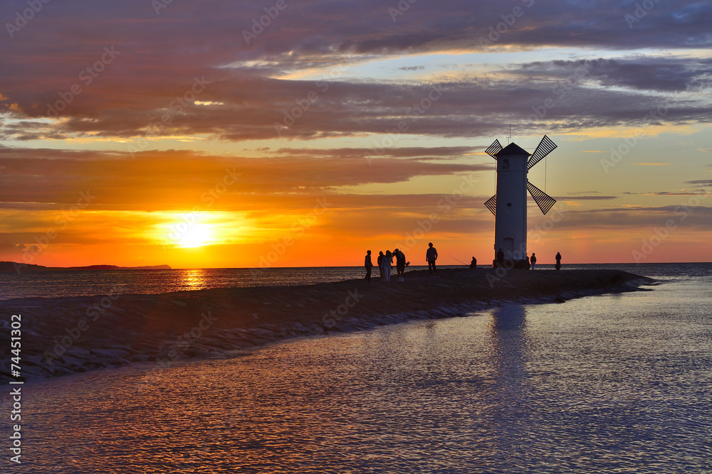 Naklejka premium Sunset over the sea with lighthouse
