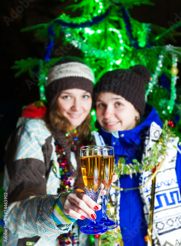 Two girls with Christmas champagne outdoors