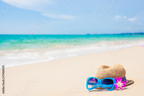 sunglasses and hat on tropical beach