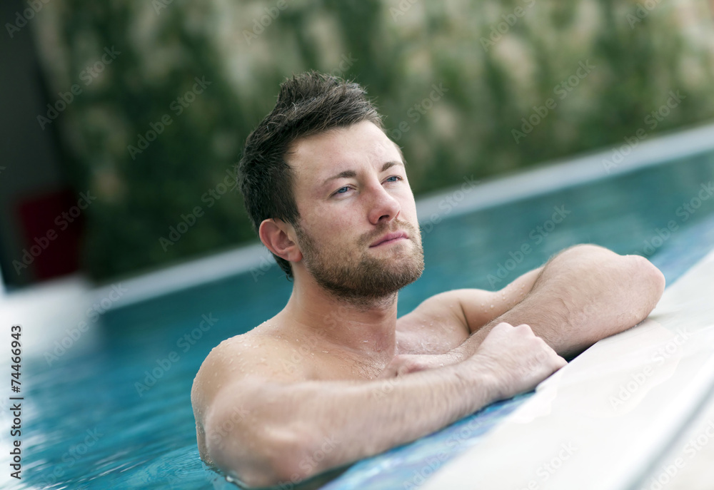 Young man leaning at edge of swimming pool Young man leaning at edge of swimming pool