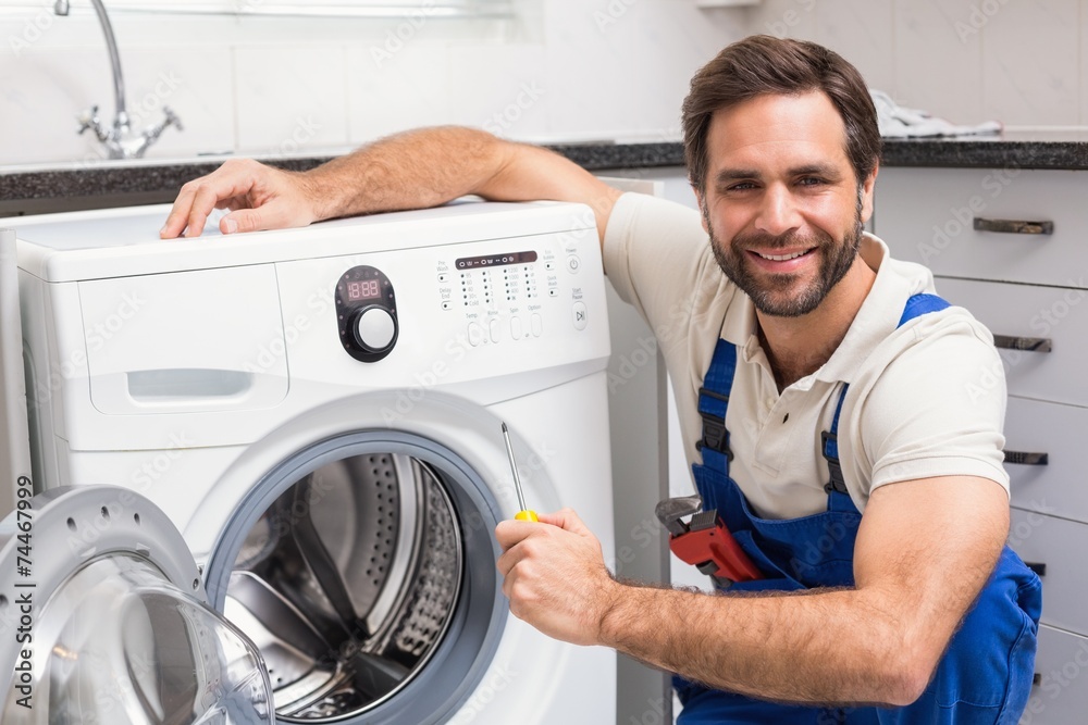 Handyman fixing a washing machine Handyman fixing a washing machine