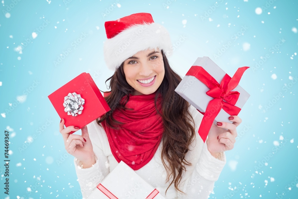 Composite image of happy brunette holding christmas gifts Composite image of happy brunette holding christmas gifts