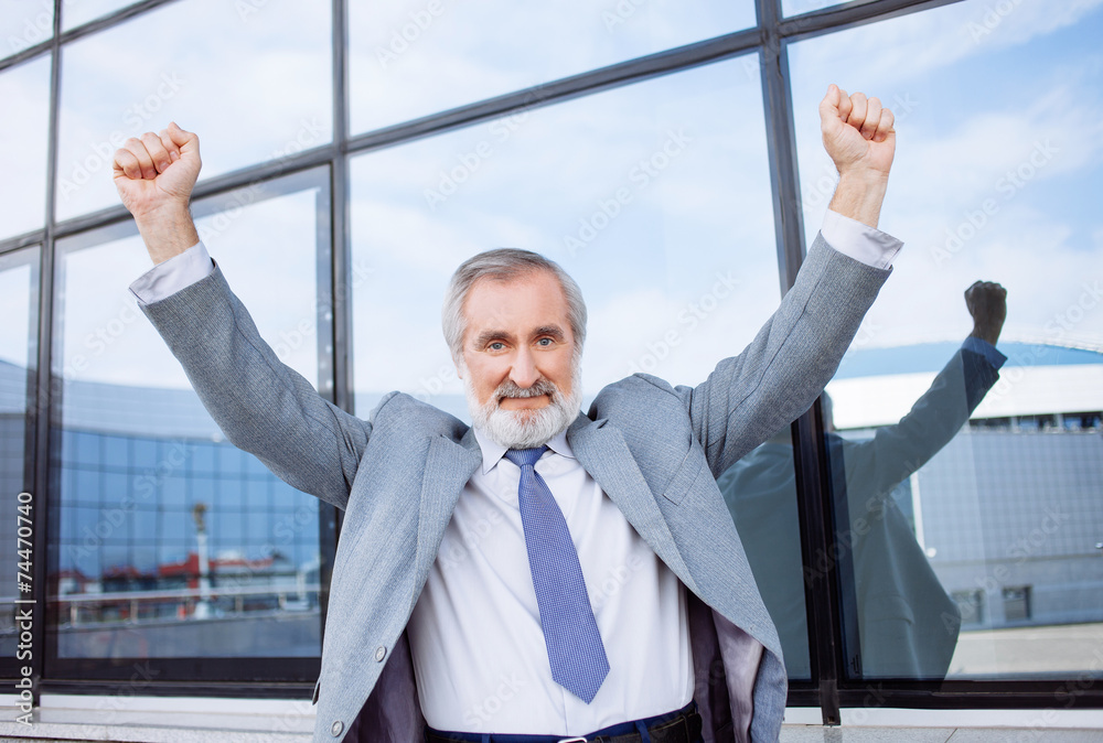 Successful man celebrating with arms up
