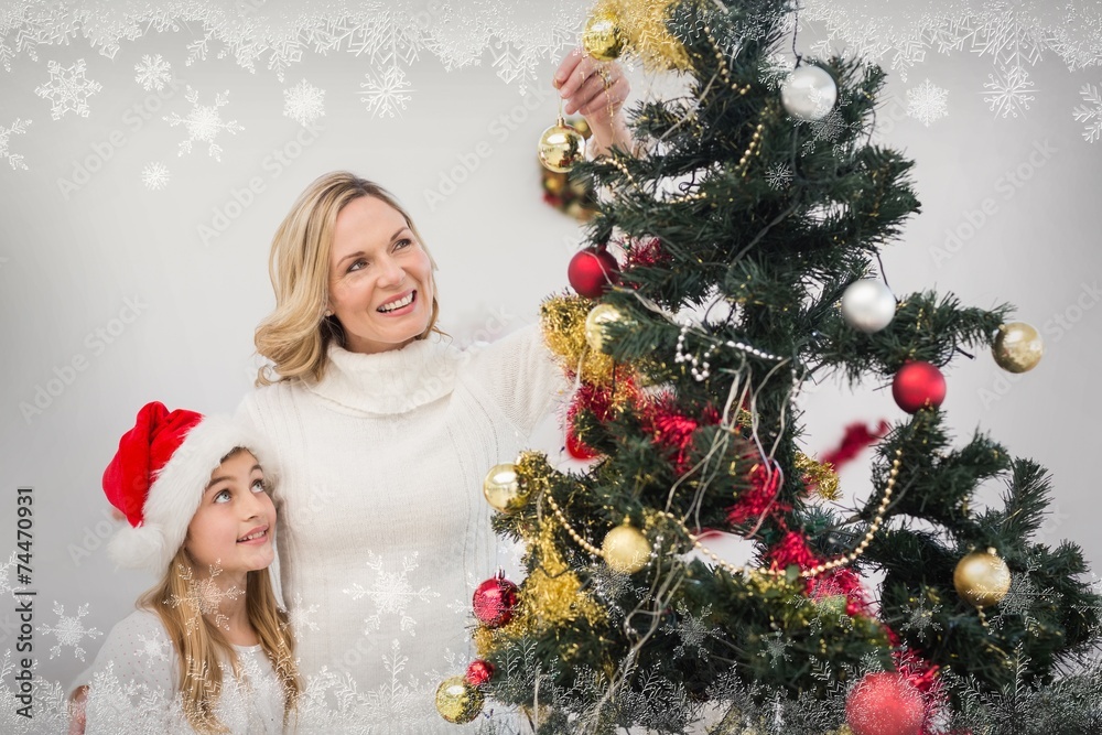 Mother and daughter decorating christmas tree Mother and daughter decorating christmas tree