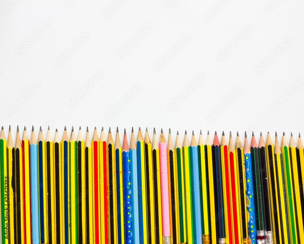 colorful pencils on the white paper, view from above colorful pencils on the white paper, view from above